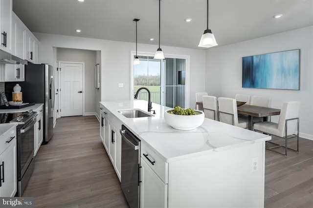 kitchen featuring pendant lighting, white cabinets, sink, an island with sink, and stainless steel appliances