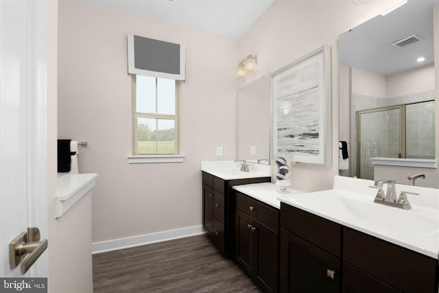 bathroom with vanity, wood-type flooring, and a shower with shower door