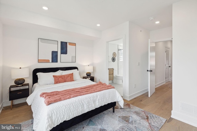 bedroom featuring ensuite bathroom and light hardwood / wood-style floors