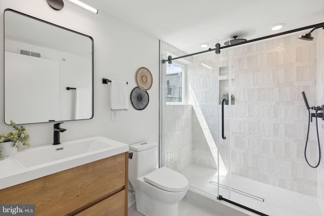 bathroom with tile patterned floors, vanity, toilet, and walk in shower