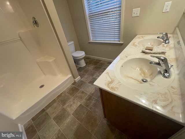 bathroom featuring vanity, toilet, and walk in shower