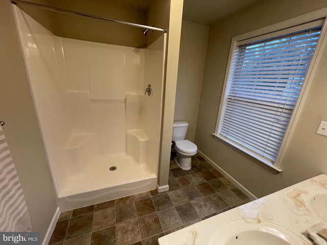 bathroom featuring vanity, toilet, and walk in shower