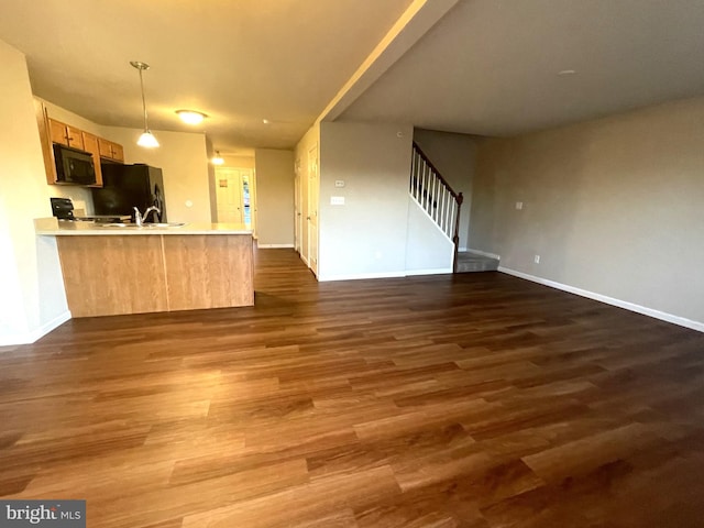 kitchen featuring light brown cabinets, dark hardwood / wood-style flooring, kitchen peninsula, pendant lighting, and black appliances