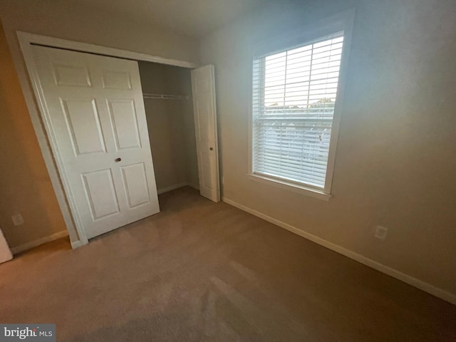 unfurnished bedroom with carpet flooring and a closet