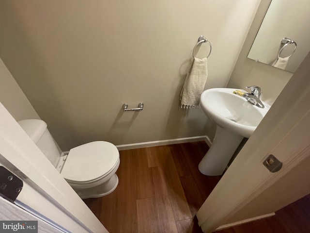 bathroom featuring hardwood / wood-style flooring, toilet, and sink