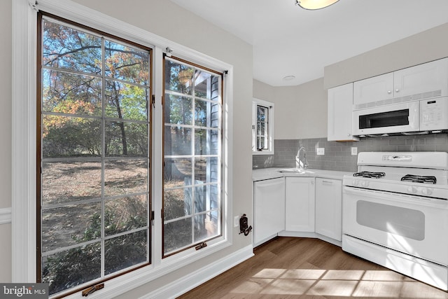 kitchen featuring decorative backsplash, white appliances, sink, dark hardwood / wood-style floors, and white cabinetry