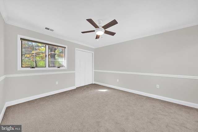 carpeted spare room featuring ceiling fan and ornamental molding