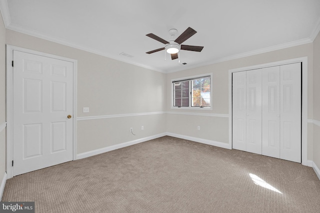 unfurnished bedroom featuring light carpet, a closet, ceiling fan, and crown molding