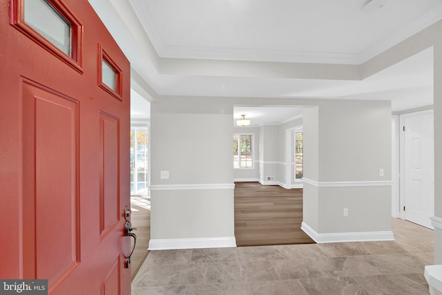 foyer entrance featuring crown molding and light hardwood / wood-style flooring