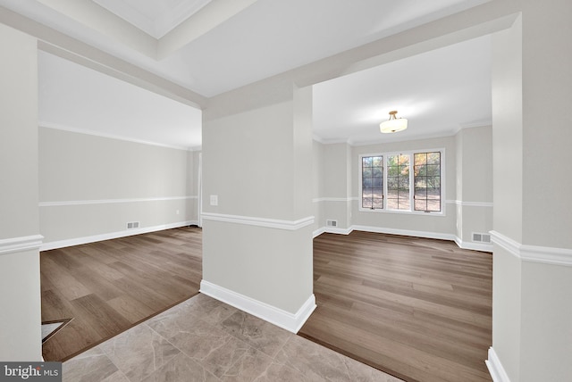 empty room with crown molding and wood-type flooring