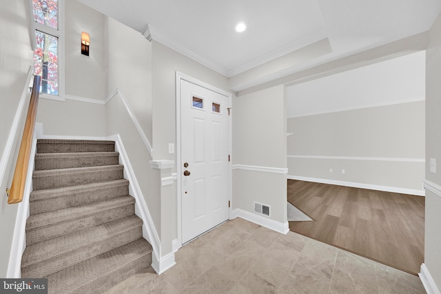 foyer with light wood-type flooring and ornamental molding