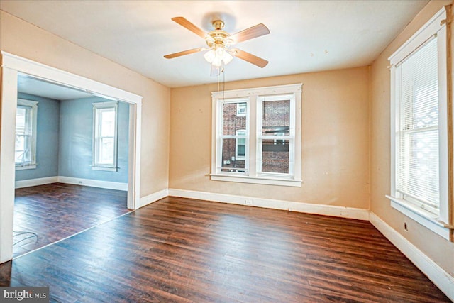 spare room featuring ceiling fan, dark hardwood / wood-style flooring, and a wealth of natural light