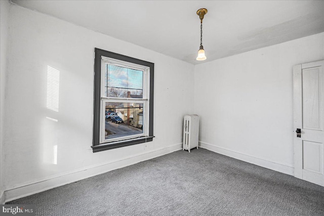 unfurnished room featuring radiator heating unit and carpet floors