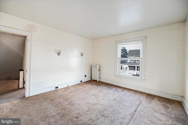 empty room with carpet flooring and radiator heating unit