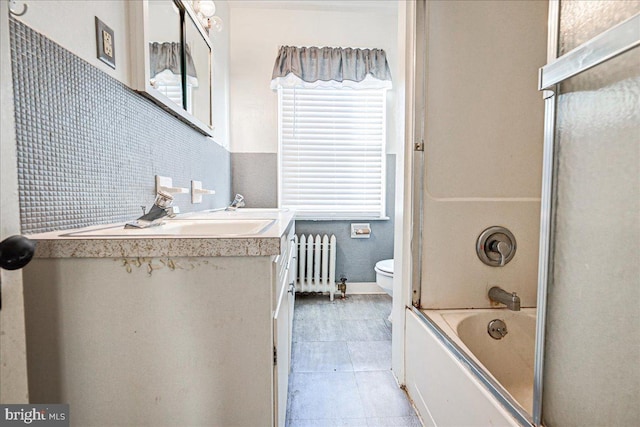 full bathroom with vanity, tile patterned flooring, toilet, enclosed tub / shower combo, and radiator heating unit