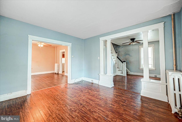 unfurnished living room featuring dark hardwood / wood-style floors, ceiling fan, and radiator