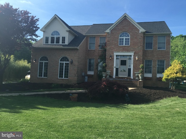 colonial inspired home featuring a front yard