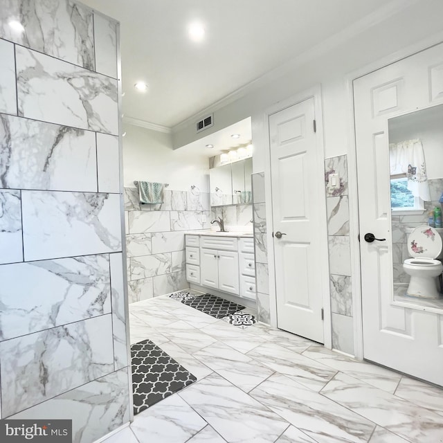 bathroom featuring vanity, tile walls, and crown molding