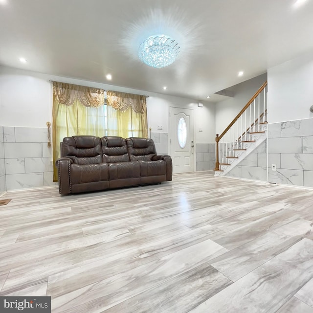 living room featuring a chandelier and tile walls