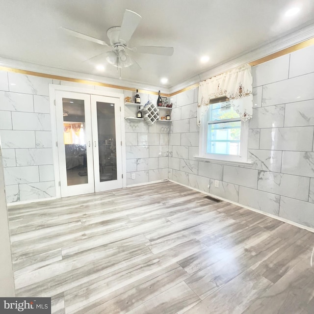 unfurnished dining area featuring ceiling fan, french doors, and crown molding