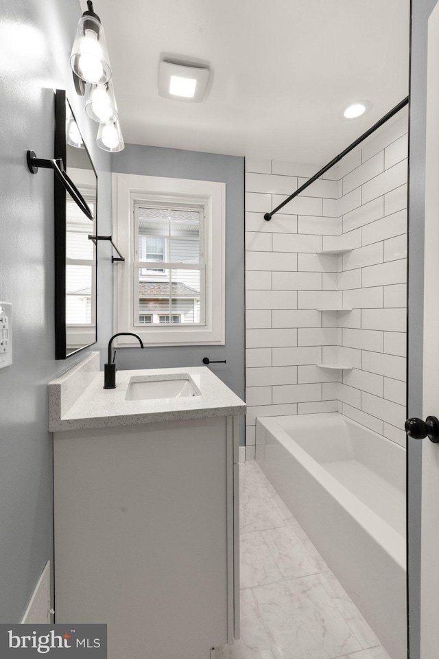 bathroom featuring vanity and tiled shower / bath