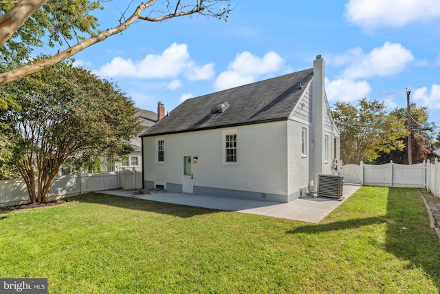 rear view of house featuring a patio area, a yard, and central AC