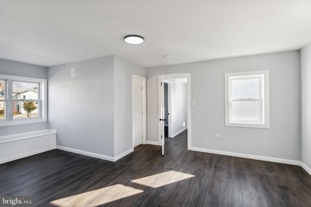 unfurnished room with dark wood-type flooring