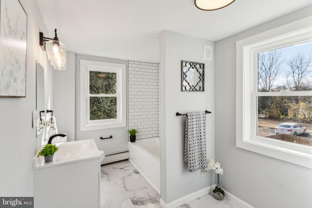 bathroom featuring vanity, baseboard heating, a bath, and a wealth of natural light