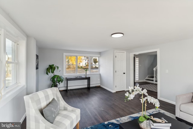 living room featuring baseboard heating and dark hardwood / wood-style flooring