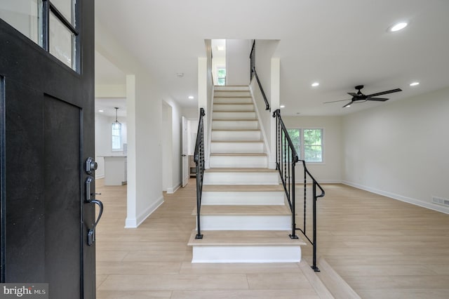 staircase featuring hardwood / wood-style floors and ceiling fan