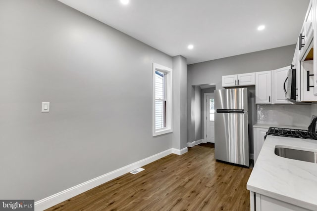 kitchen featuring white cabinets, sink, dark hardwood / wood-style floors, appliances with stainless steel finishes, and tasteful backsplash