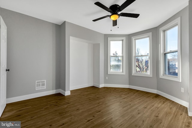 spare room with wood-type flooring, a wealth of natural light, and ceiling fan