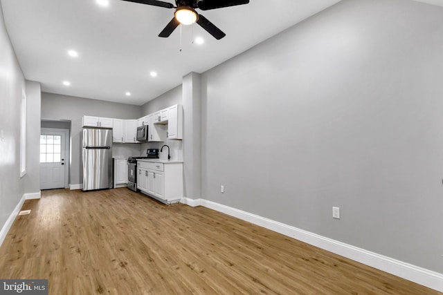 kitchen featuring white cabinets, sink, stainless steel appliances, and light hardwood / wood-style flooring