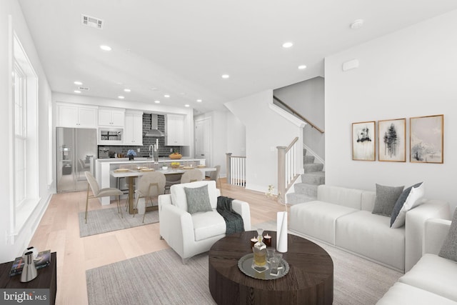 living room with light wood-type flooring and sink