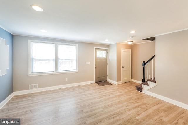 entryway featuring ornamental molding and light hardwood / wood-style flooring