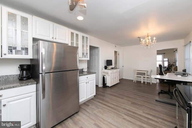 kitchen featuring light wood-type flooring, freestanding refrigerator, white cabinets, and glass insert cabinets