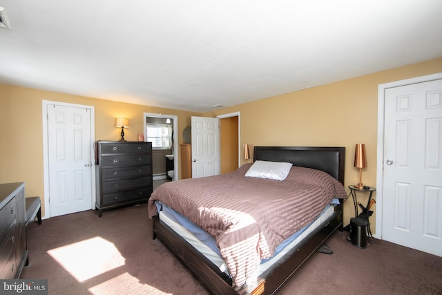 carpeted bedroom featuring a baseboard heating unit and visible vents