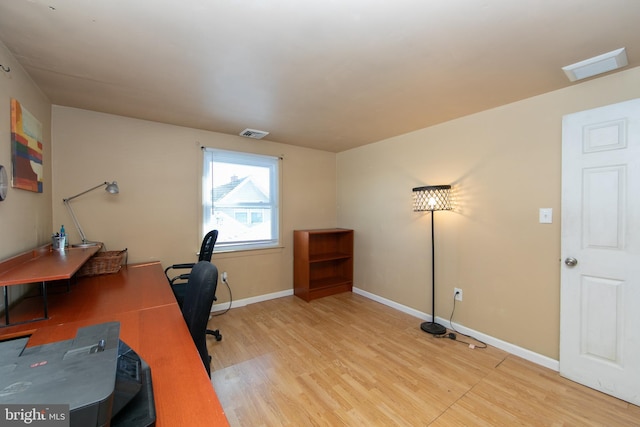 office space with light wood-type flooring, baseboards, and visible vents