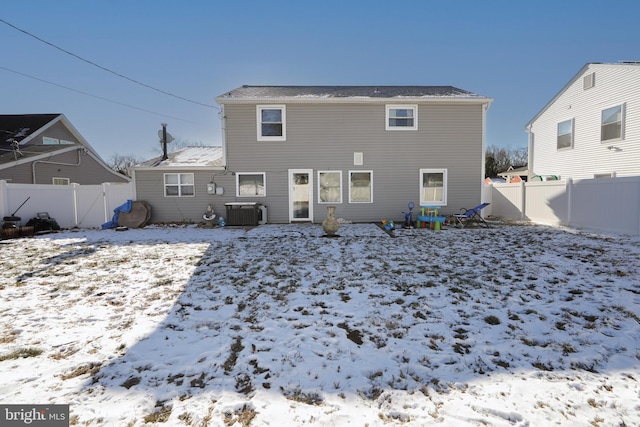 snow covered house featuring fence and central air condition unit