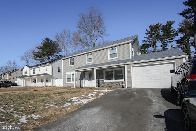 view of front of house with aphalt driveway, a porch, a garage, stone siding, and a residential view