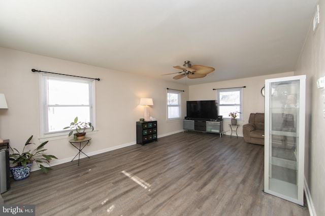 unfurnished living room featuring ceiling fan, baseboards, and wood finished floors