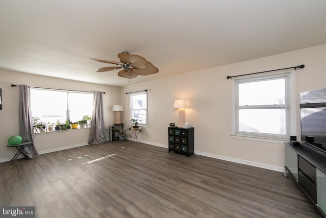 interior space featuring wood finished floors, a ceiling fan, and baseboards