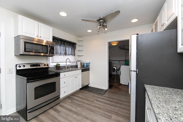 kitchen with a sink, appliances with stainless steel finishes, wood finished floors, and white cabinets