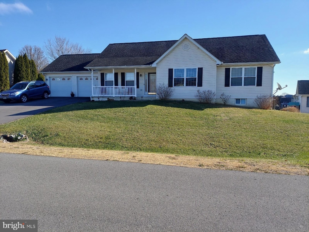 ranch-style house with covered porch, a garage, and a front yard