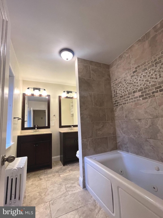 bathroom featuring radiator heating unit, vanity, toilet, and a bathtub