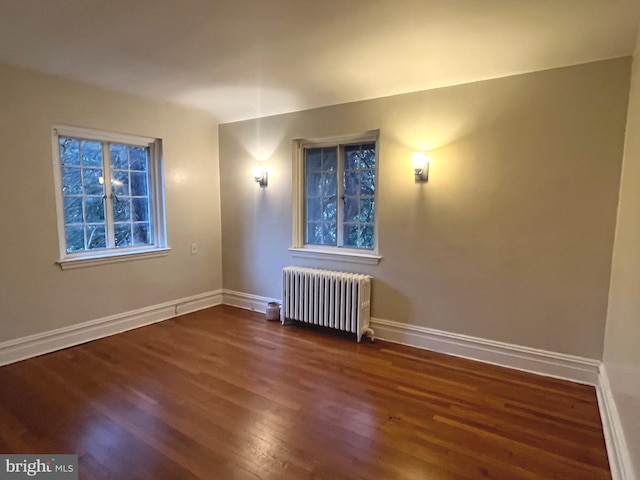 unfurnished room with radiator and dark hardwood / wood-style floors