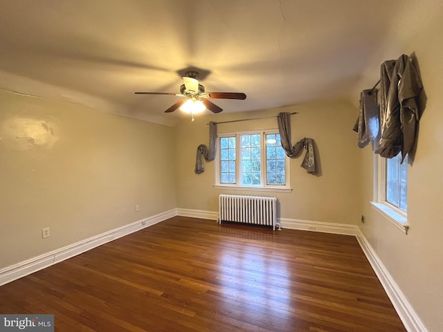 spare room featuring ceiling fan, radiator heating unit, and dark wood-type flooring