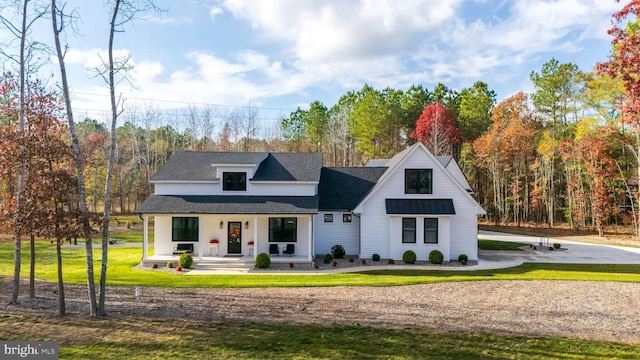 modern inspired farmhouse featuring a porch and a front yard