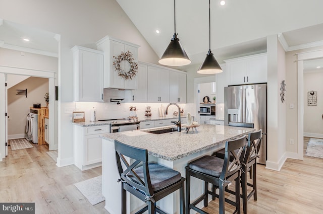 kitchen featuring white cabinets, light wood-type flooring, stainless steel appliances, and sink