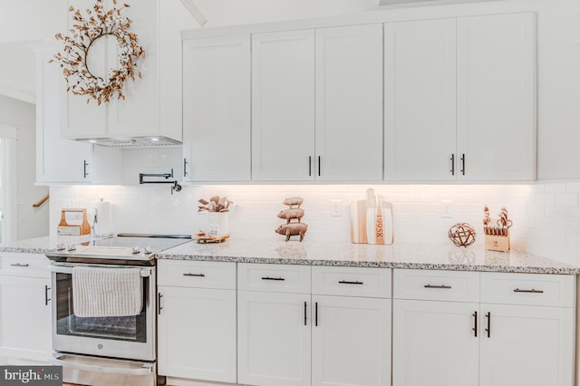 kitchen with white cabinetry, stainless steel electric range oven, tasteful backsplash, and light stone counters